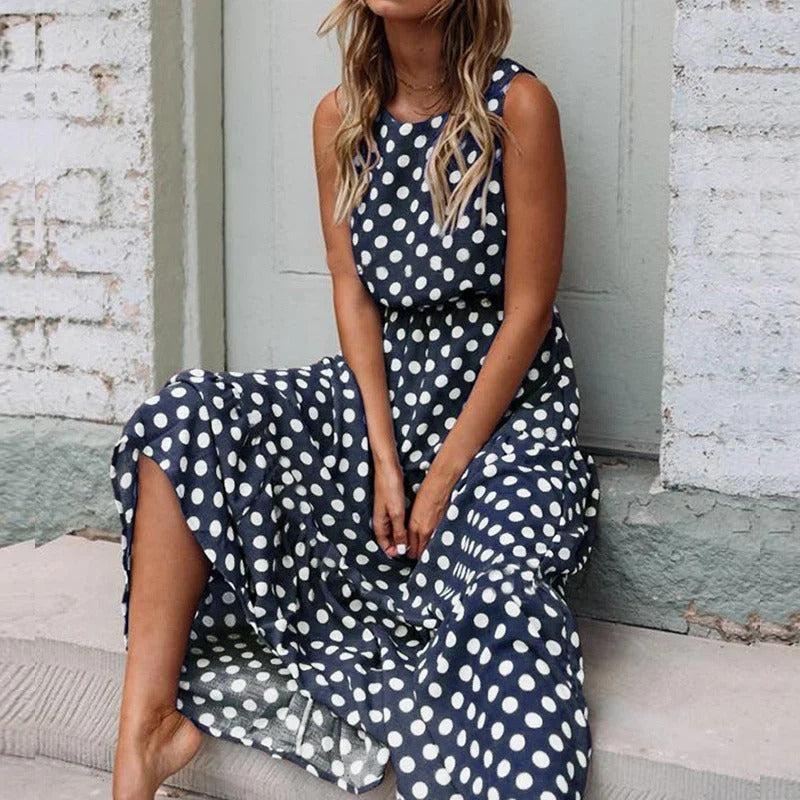 Woman seated on stone steps wearing the navy blue polka dot dress with a full, flowing skirt 5
