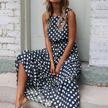 Woman seated on stone steps wearing the navy blue polka dot dress with a full, flowing skirt 5