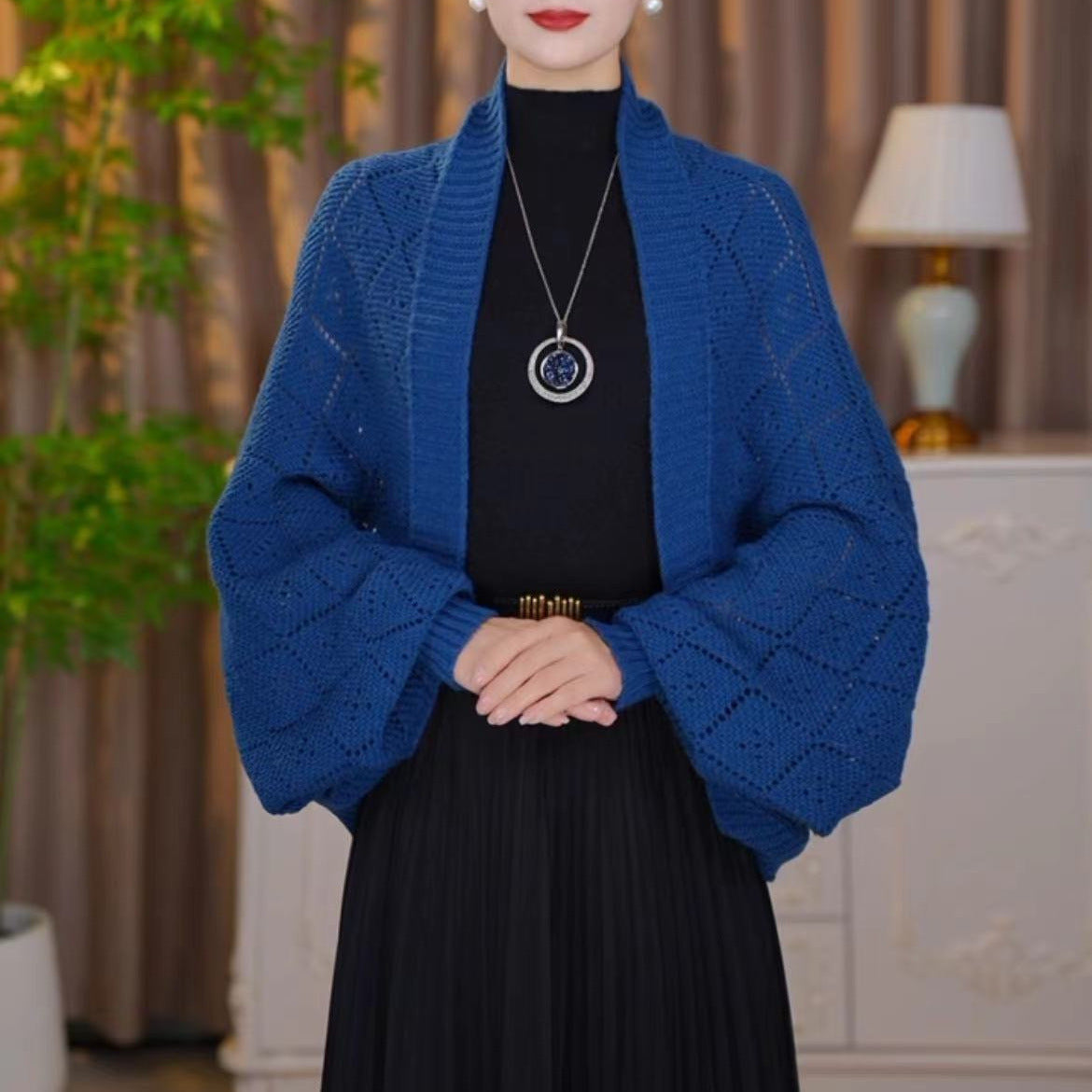 Second view of the royal blue open knit shawl cardigan worn with a pendant necklace 17