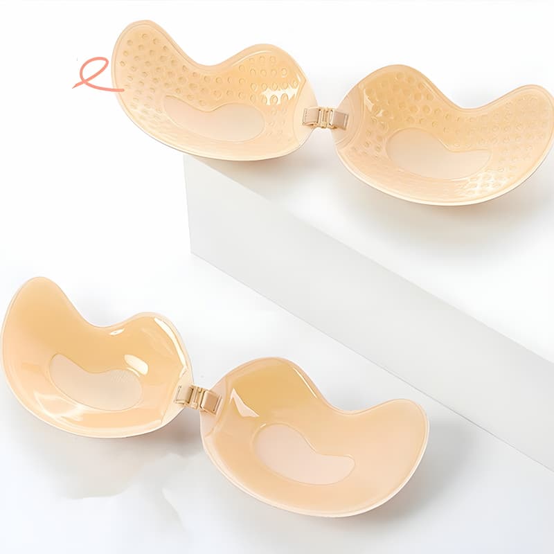 Two beige adhesive bras laid flat showing the sticky inner surface, one with a dotted texture, joined by clasps. 8