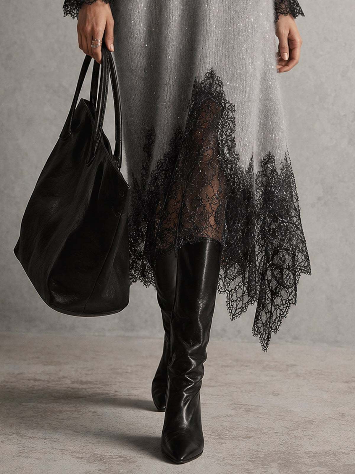 Close-up of the black lace panel along the dress hem, with black leather boots and tote 7