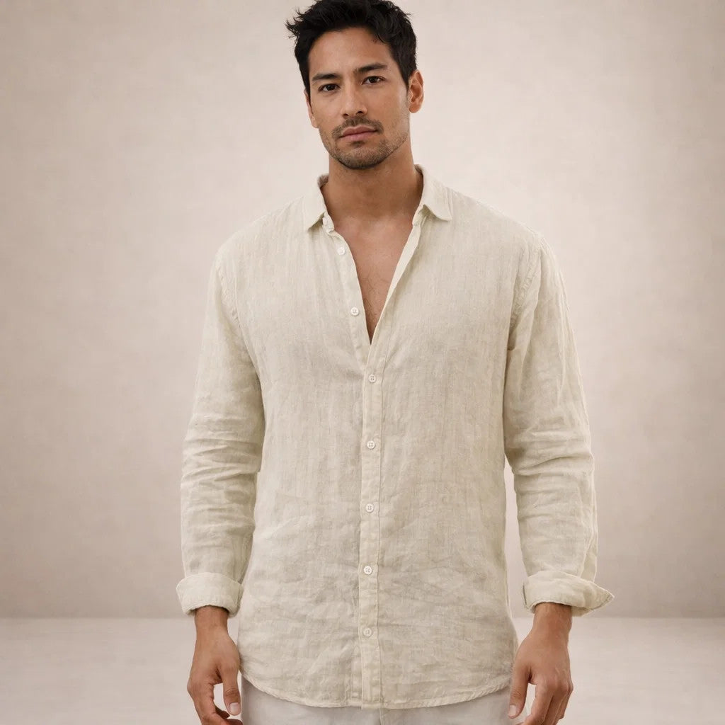 Model facing the camera in a cream natural-toned linen shirt, loosely buttoned with sleeves rolled and pale trousers. 11