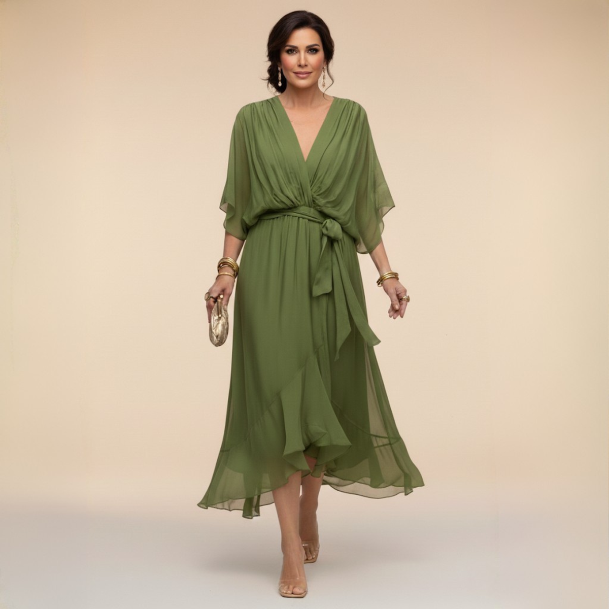 Model walking in the olive green chiffon midi dress with draped V-neck, tied waist sash and ruffled hem, holding a gold clutch. 1