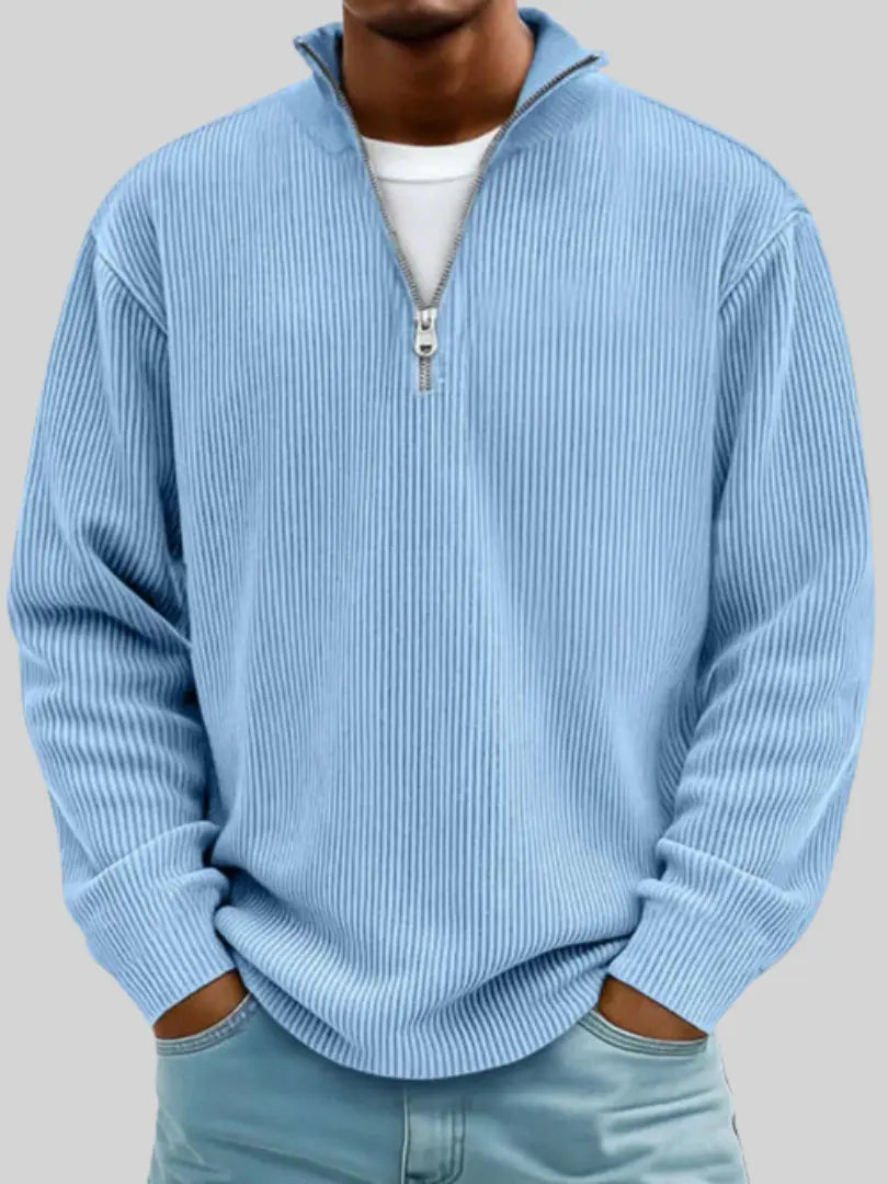 Man wearing the ribbed quarter-zip jumper in light blue over a white tee, hands in pockets of pale jeans. 1