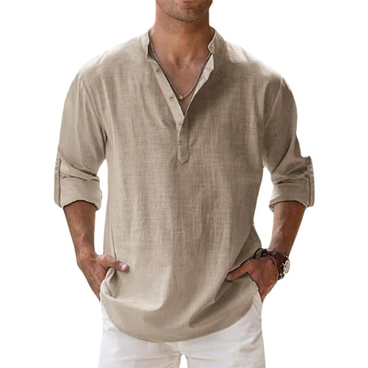 Model wearing the beige Henley shirt with sleeves rolled up and hands in the pockets of white trousers. 1