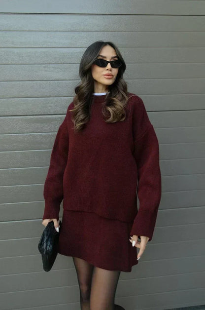 Front view of the burgundy set on a model, oversized sweater over a flared mini skirt 2