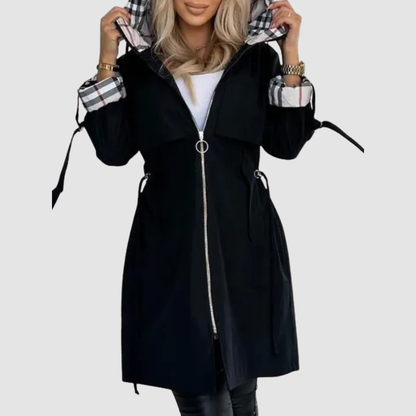 Black version of the coat zipped up with a ring pull, hood raised to show the checked lining and side waist ties. 3