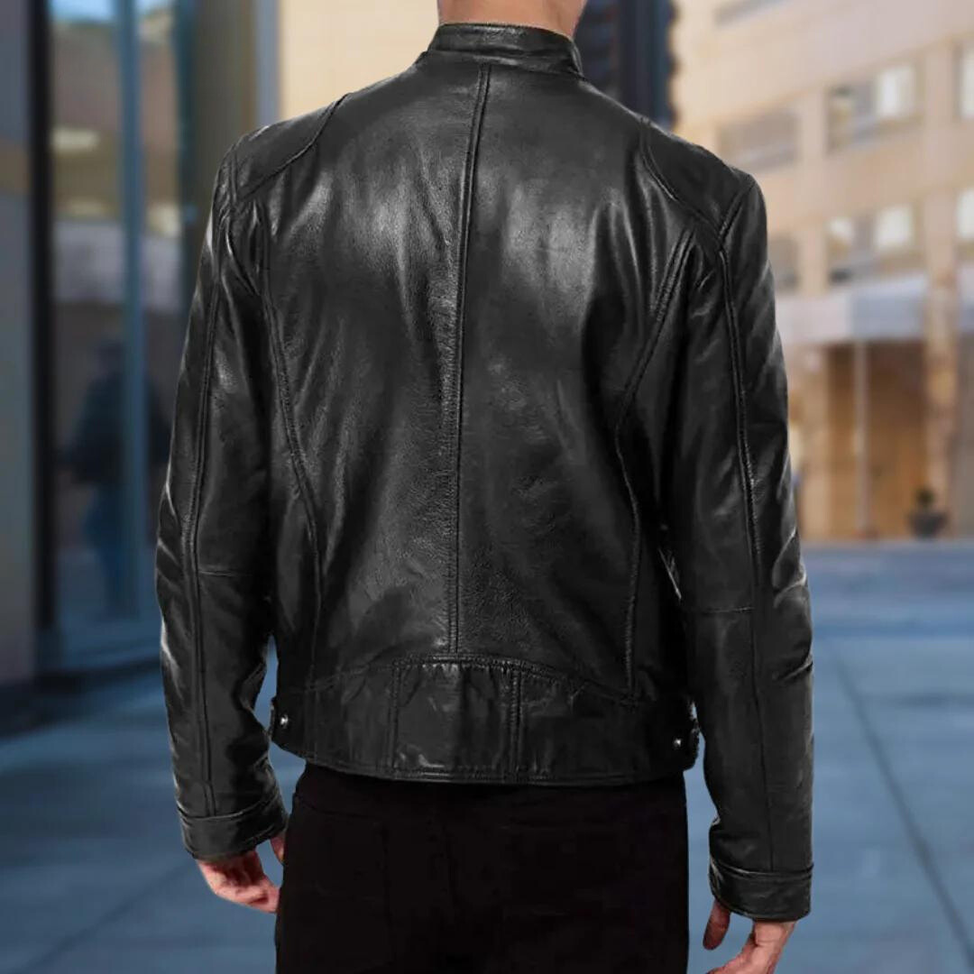 Back view of a man wearing the black leather jacket in a city street, showing the seamed back panels and cuffs. 5