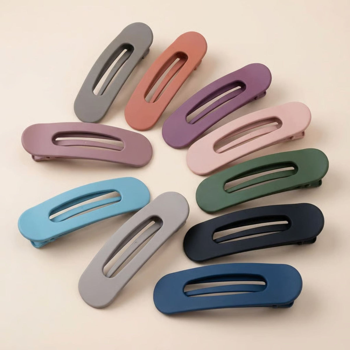 Ten matte flat clips fanned out in a circle in grey, terracotta, purple, pink, green, blue and navy 1