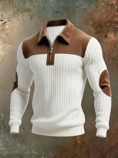 White ribbed quarter-zip jumper with brown suede-look collar, yoke and elbow patches, shown on an invisible mannequin against a rustic backdrop. 1
