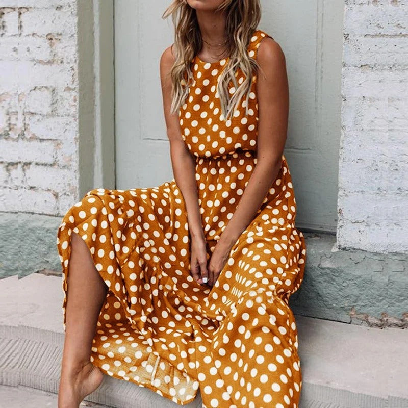 Woman seated on stone steps wearing the mustard yellow polka dot dress with a flowing skirt 3