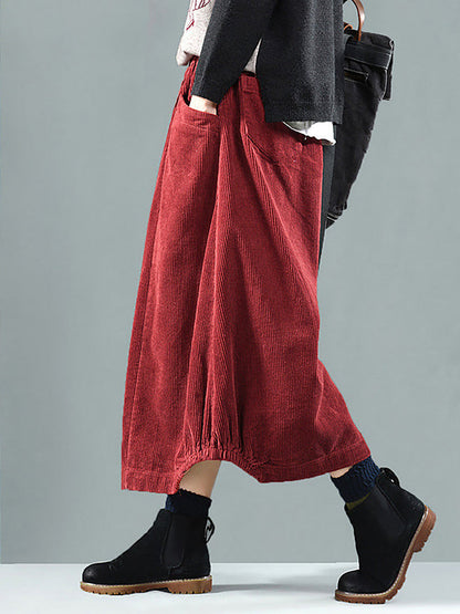 Side view of the red corduroy skirt on a model, showing the large pocket and gathered hem 2