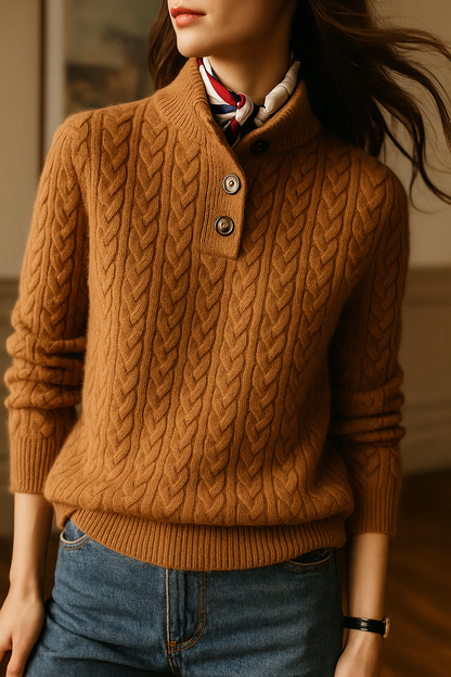 Model in the caramel-brown cable-knit sweater with scarf knotted at the stand collar, turned to the side with hair in motion. 3