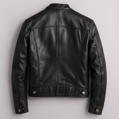 Back view of the black leather jacket laid flat, showing the panelled seams, waist tabs with snaps and buttoned cuffs. 7