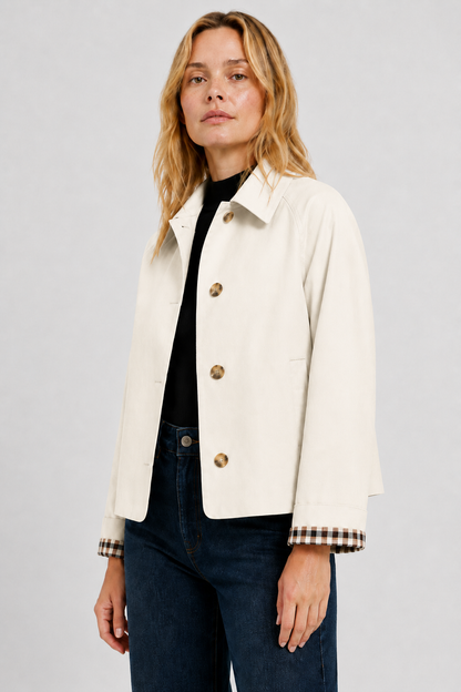 Three-quarter view of the cream jacket worn open over a black top and jeans, showing the turned-back gingham cuffs. 22