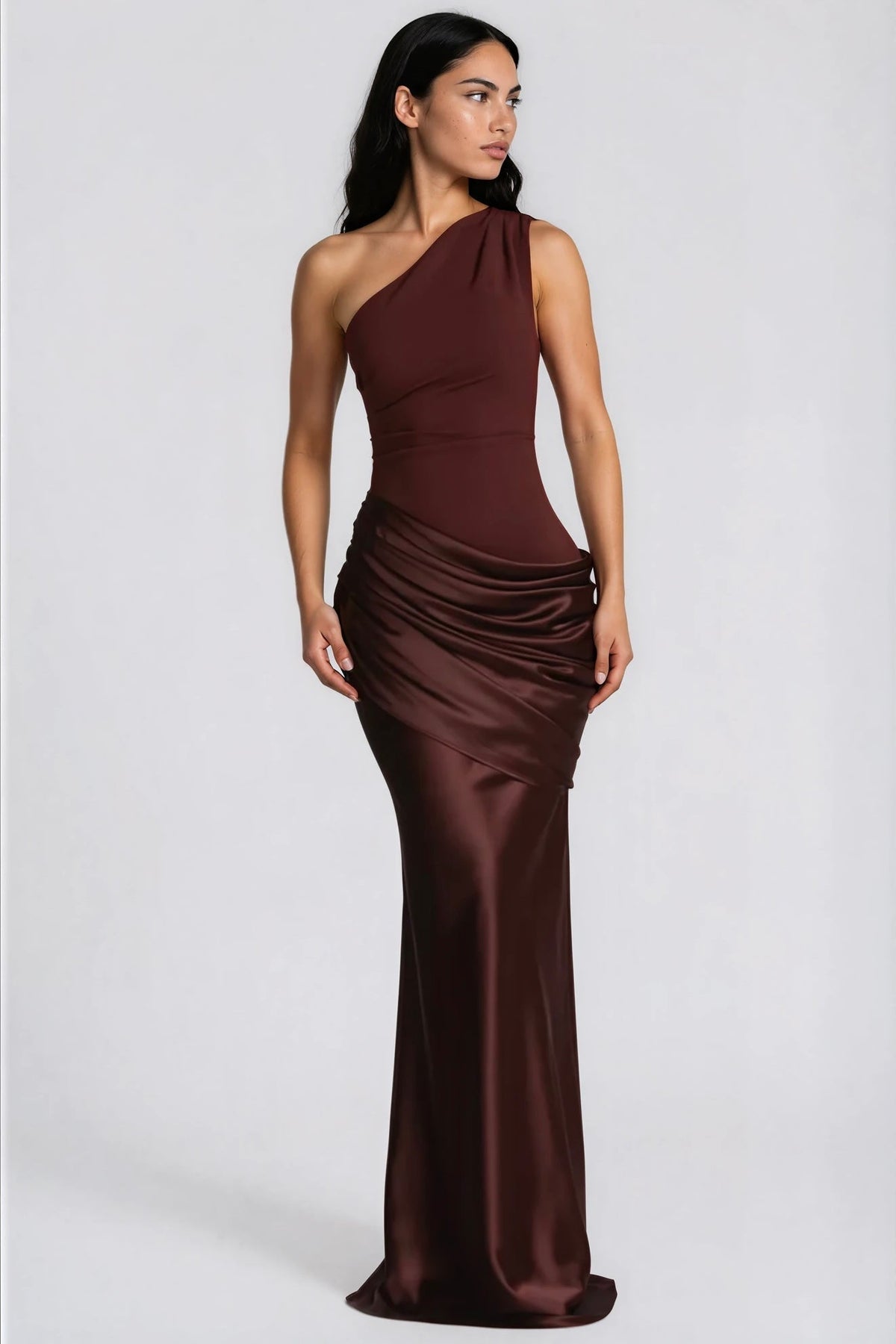 Model in deep brown satin gown with one shoulder and draped waist, angled front view 6