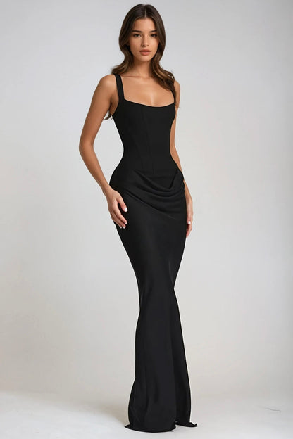 Model wears the black maxi dress at a three-quarter angle, showing the corset-style bodice and draped hip 25