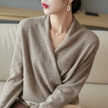 Model looking away in taupe wrap jumper, showing the draped crossover front beside a sofa 8