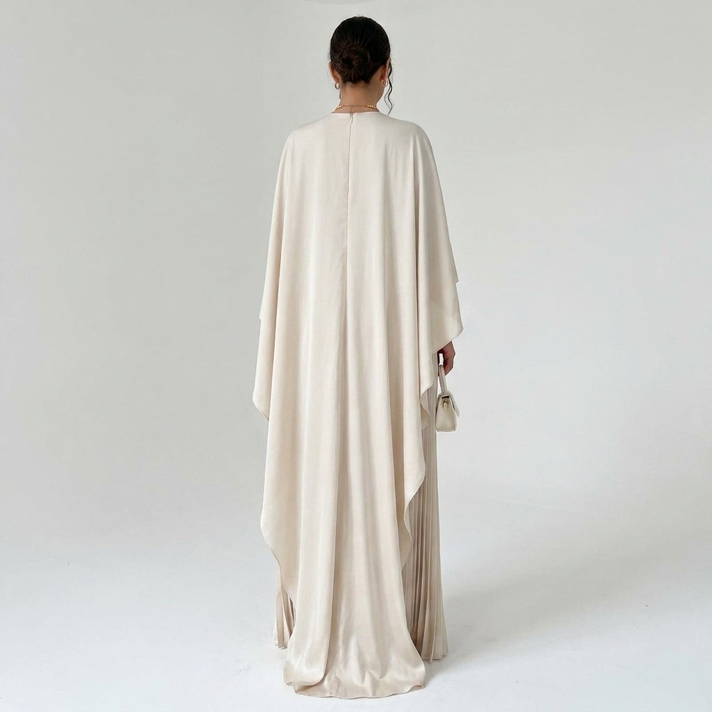 Back view of the cream dress on a model, with a centre zip and long flowing cape 3