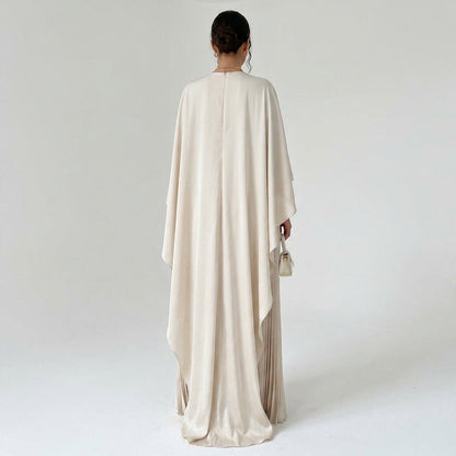 Back view of the cream dress on a model, with a centre zip and long flowing cape 3