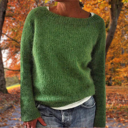 Green knit sweater with a wide neckline, worn by a model with a white top and jeans outdoors 5