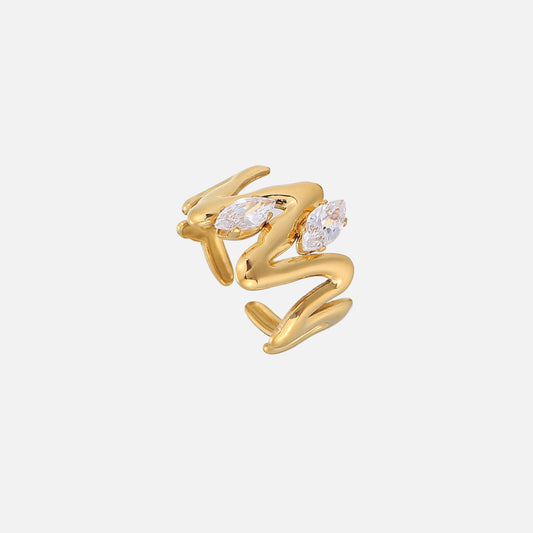Gold-toned open ring with a wavy, molten-looking band and two clear marquise-cut stones, shown from an angled top view on a plain background. 1