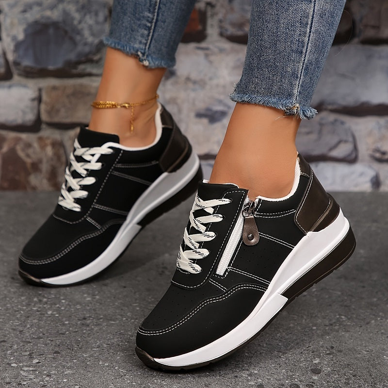 Black trainers worn with frayed jeans, showing white laces, contrast stitching and a side zip 4