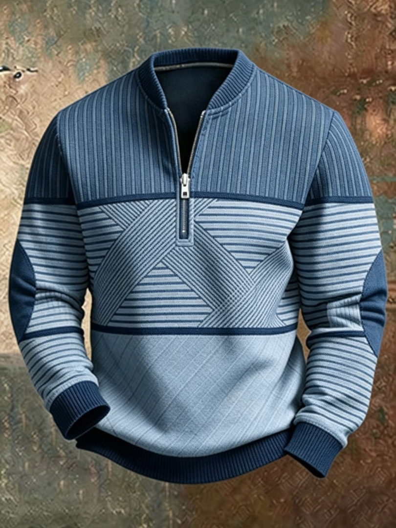 Front view of the jumper in two tones of blue, showing the half zip, geometric striped panel and navy ribbed cuffs. 3