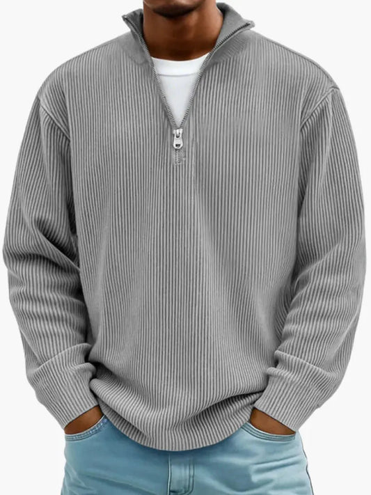 Man wearing the ribbed quarter-zip jumper in mid grey over a white tee, hands in the pockets of light blue jeans. 2