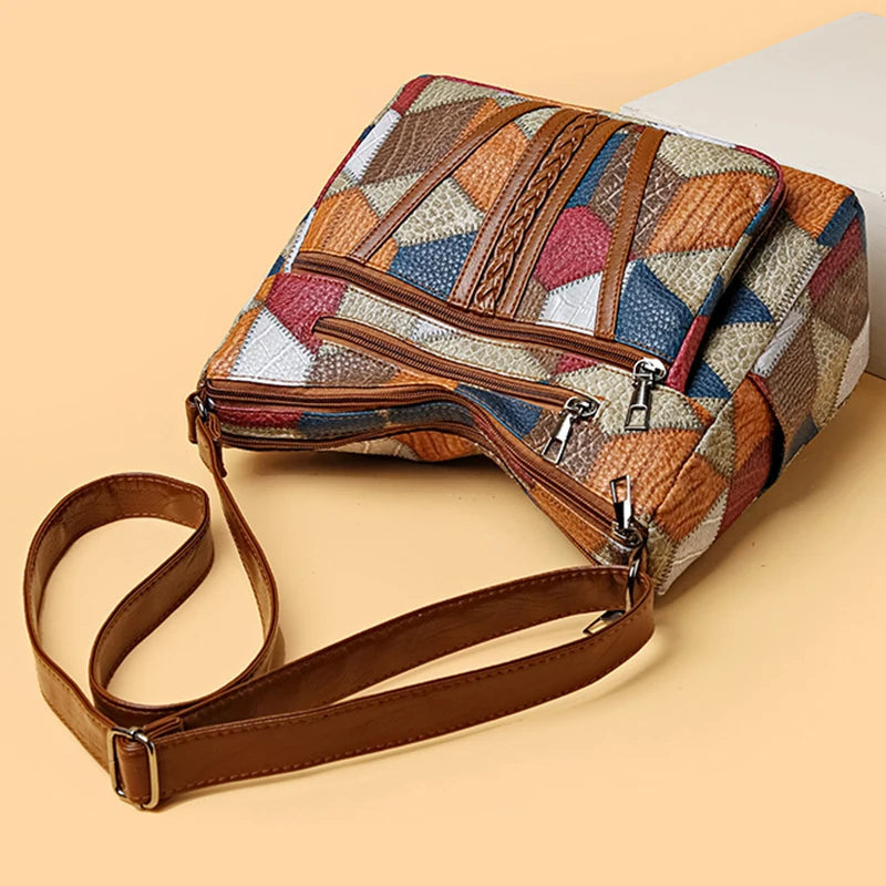 Bag lying on its side on peach, showing the top zips, the adjustable strap with buckle and the front pockets. 7