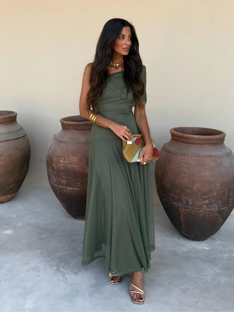 Full-length front view of olive green one-shoulder mesh dress with gathered bodice, beside clay pots 10
