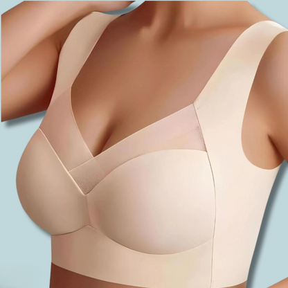 Model wearing the light beige bra from the front, with one hand raised, showing the mesh panel and wide straps. 4