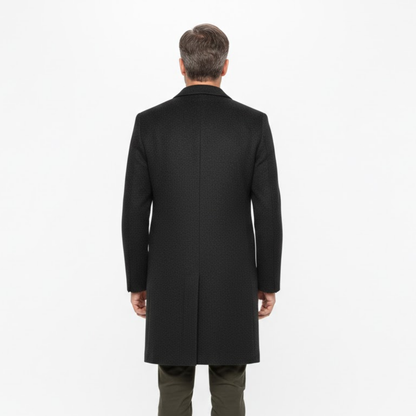 Back view of the dark coat on a male model, showing the plain back panel and centre vent 3
