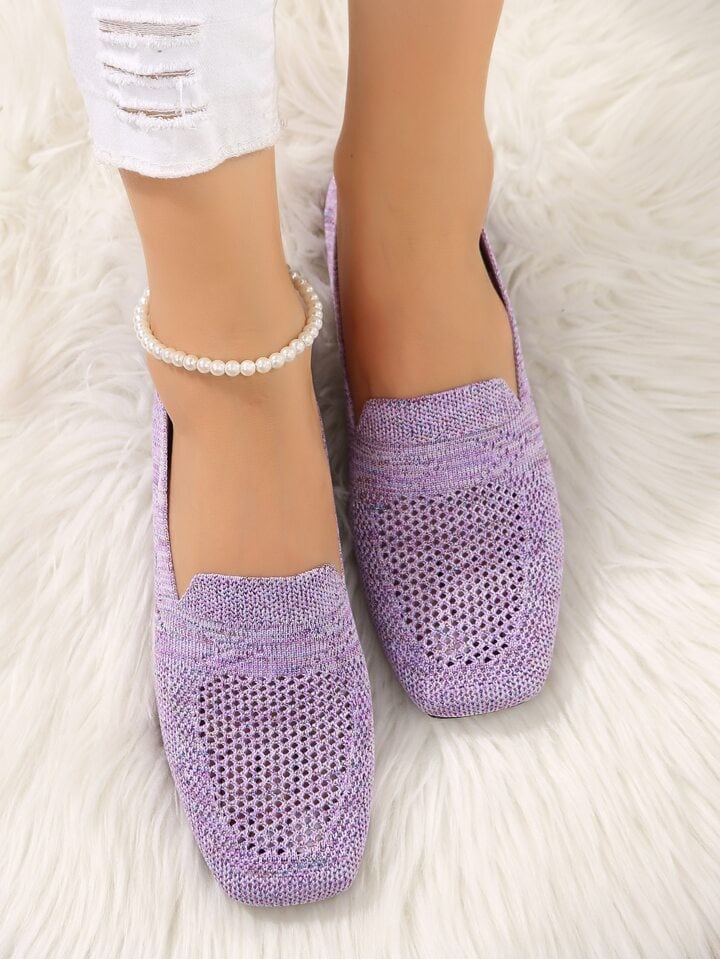 Purple knit mesh slip-ons with perforated toes worn on a fluffy white rug, with a pearl anklet and white jeans. 10