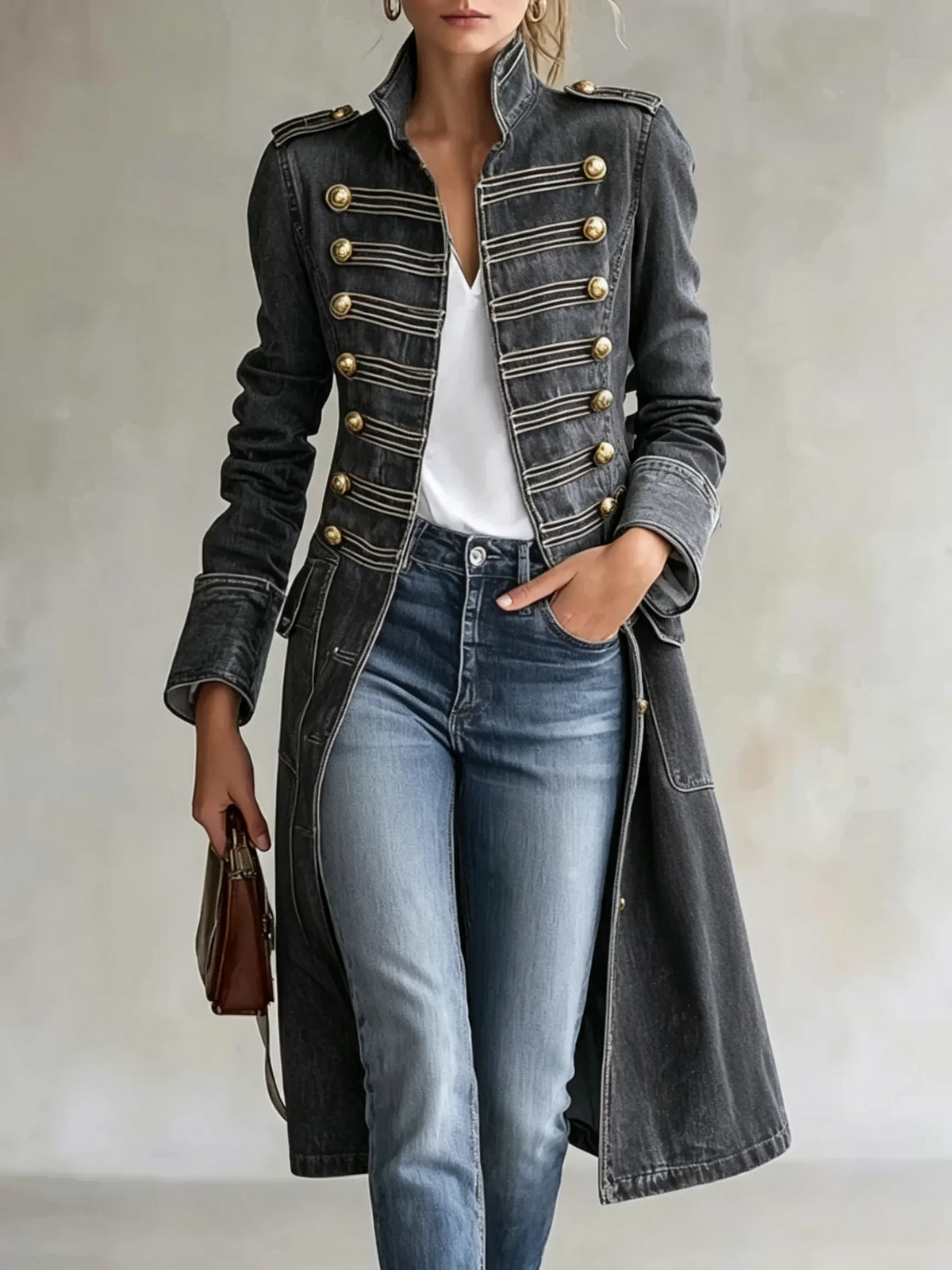 Model wearing the coat in a washed charcoal grey version with gold buttons and braiding, styled with a white top and jeans. 10
