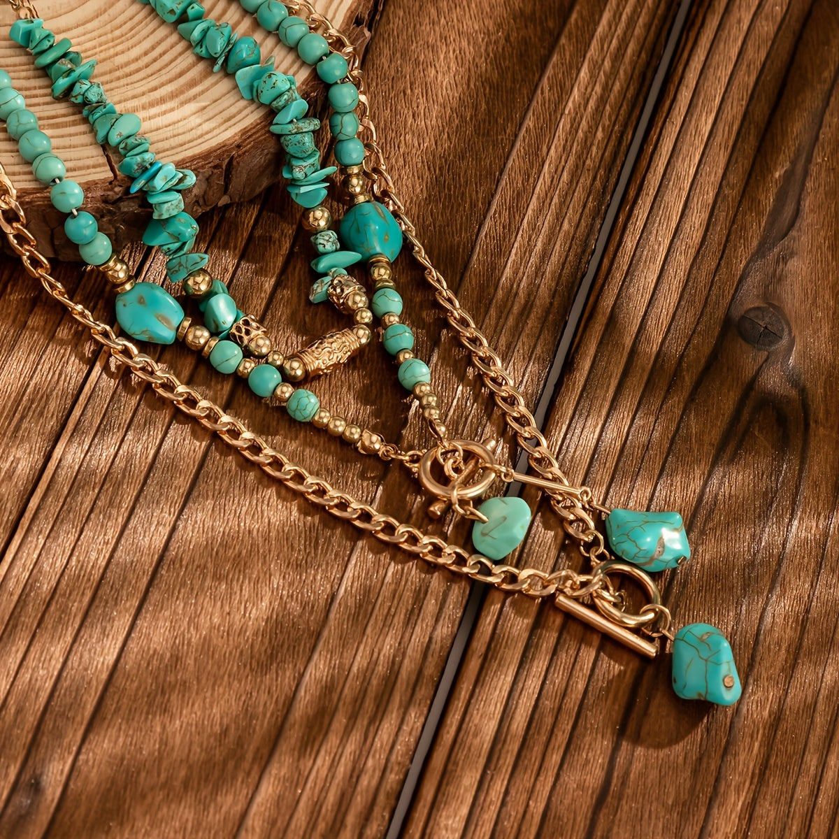 Close-up of the layered necklaces resting on dark wooden planks, showing chips, round beads and nugget pendants 4