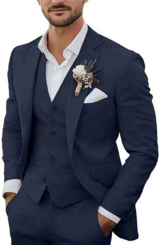 Bearded model wearing the navy three-piece suit with waistcoat, white shirt, pocket square and floral buttonhole, hands in trouser pockets. 1