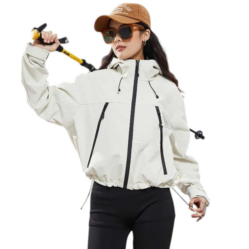 Woman in the cream jacket with the pole raised behind her shoulder, hem drawcord visible 6