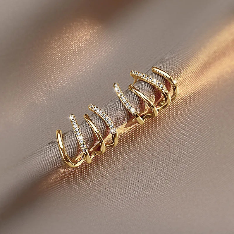 Gold-coloured pair resting on a satin fold, warm light catching the stone-set and plain bands 7