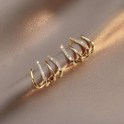 Gold-coloured pair resting on a satin fold, warm light catching the stone-set and plain bands 7