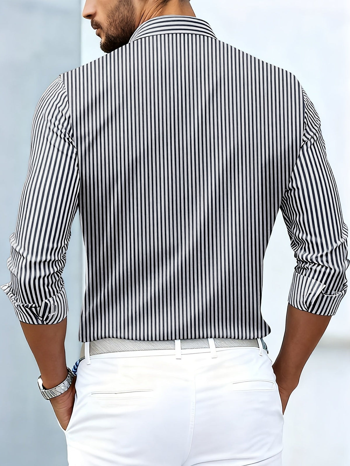 Back view of the black and white striped shirt on a model, showing plain vertical stripes across the back and sleeves. 7