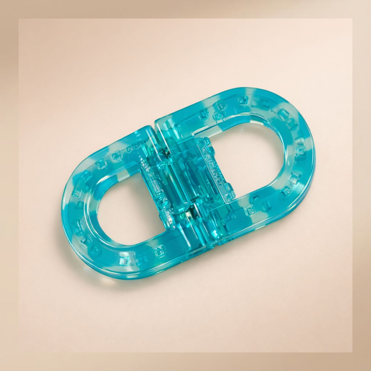 Translucent turquoise and white marbled flat hair clip with small raised squares along the edge, shown from above. 5