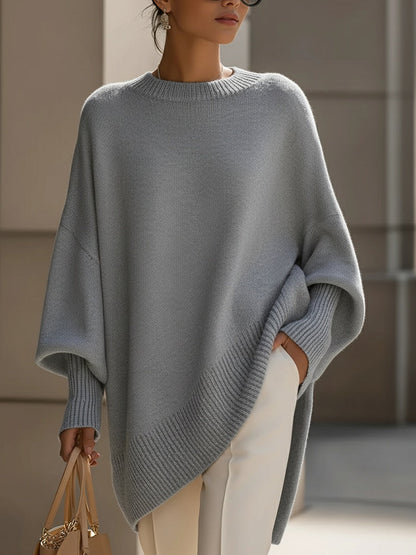 Grey version of the knit poncho on a model, showing the relaxed draped fit 10