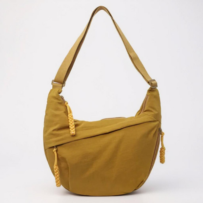 Mustard yellow crescent shoulder bag from the front, with yellow braided zip pulls and a matching adjustable strap. 8