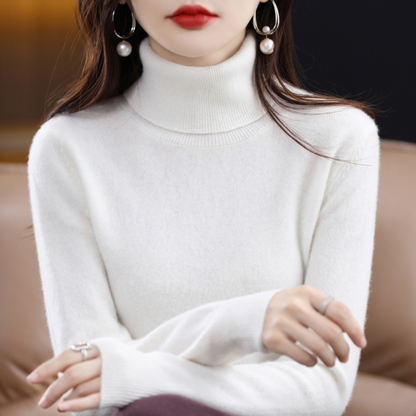 Model wearing the roll neck jumper in ivory white with arms crossed, paired with a dark plum skirt. 12