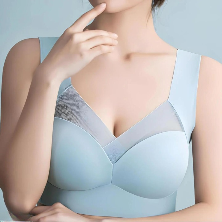 Model wearing the pale blue bra, hand held to her chin, showing the mesh V-neckline and wide shoulder straps. 5