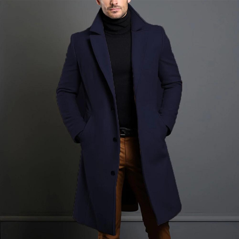 Model wearing the navy version of the single-breasted longline coat over a black roll-neck and tan trousers. 4