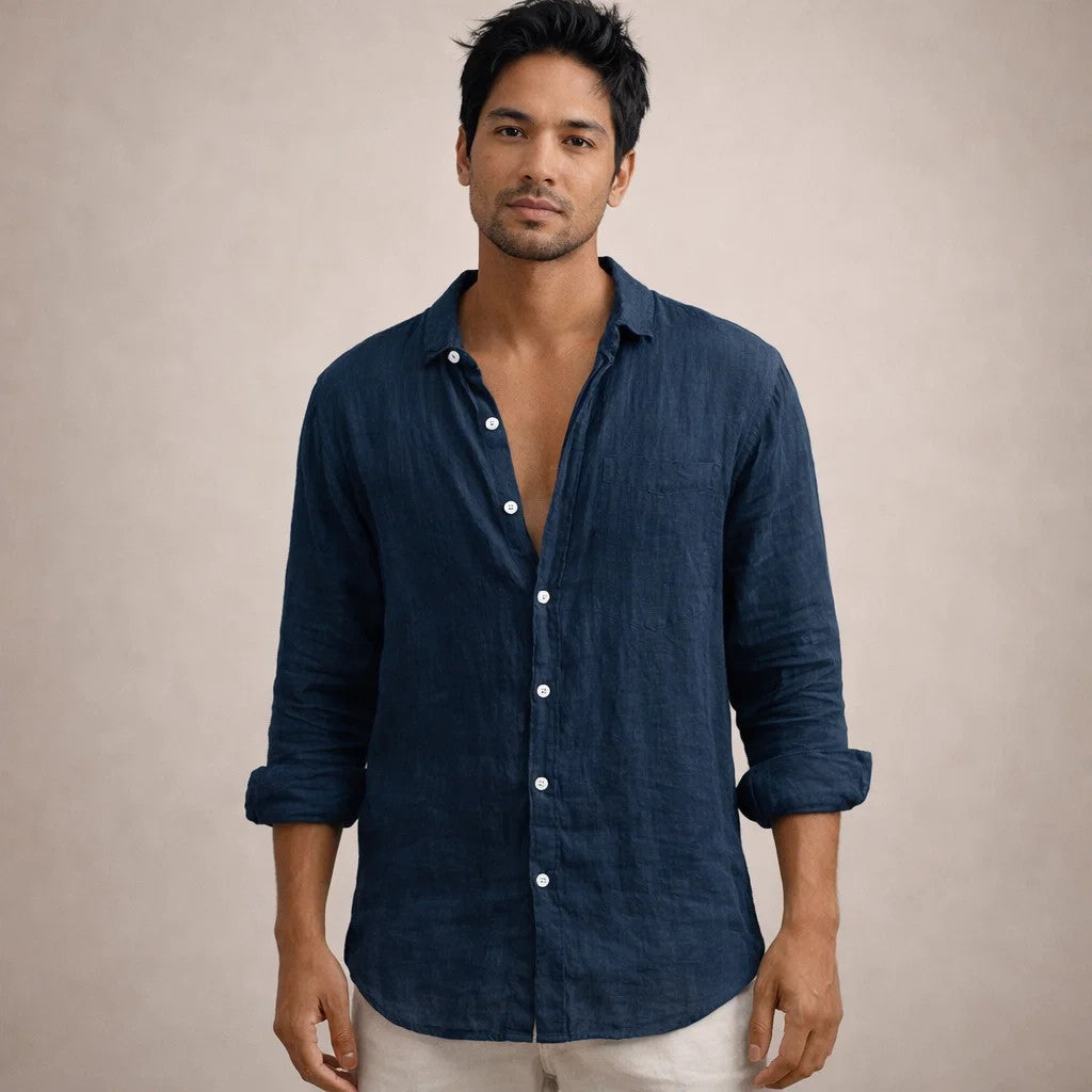 Model facing the camera in a navy linen shirt with a chest pocket, white buttons and rolled sleeves. 12