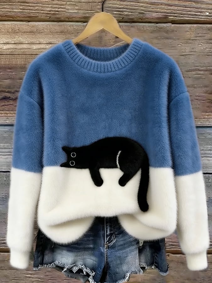 Mid-blue and white colour-block fluffy jumper on a hanger, with a black cat lying along the colour join. 9