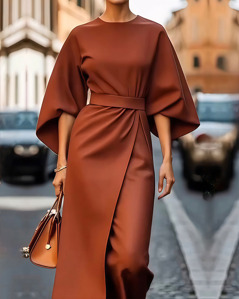 Rust-brown version of the belted dress, worn with a tan handbag on a cobbled street 3